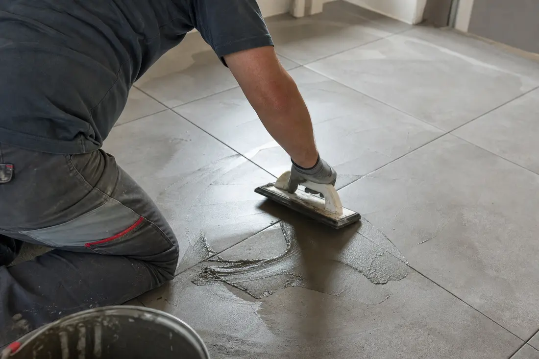 Exemple : outil de grattage des joints de carrelage en cours de réfection, illustration de chantier type